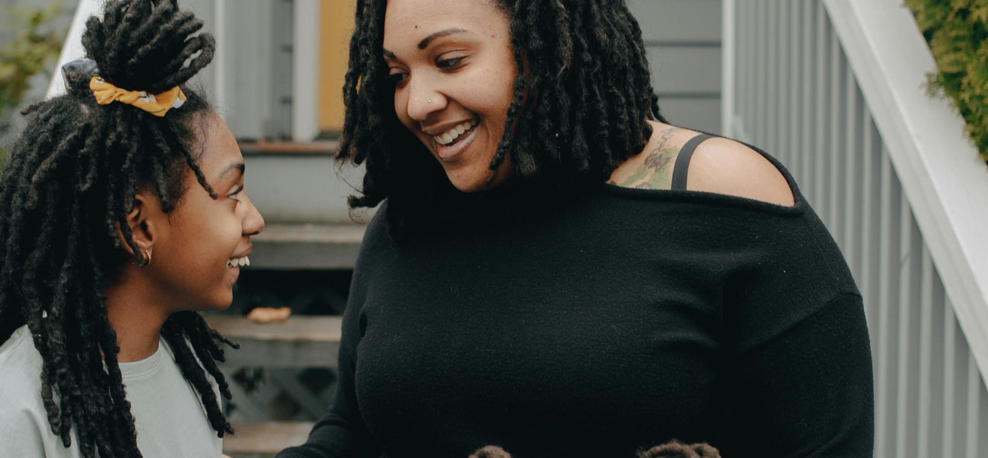 A mother and her daughters enjoying a cheerful moment together outdoors.